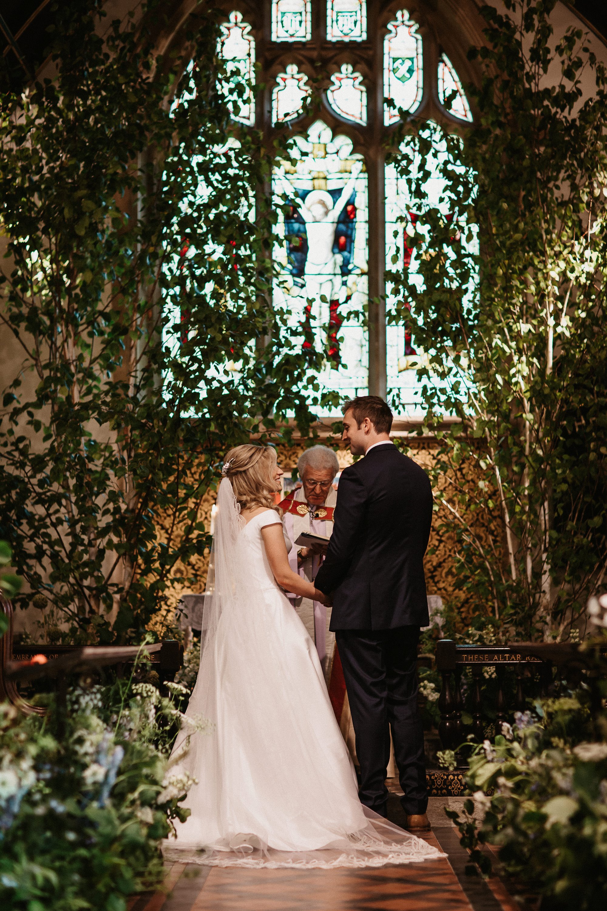 Beautiful english church wedding ceremony at Elmore church in Gloucestershire decorated with trees