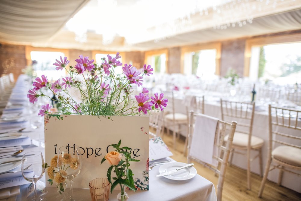 Floral wedding reception with pink flowers at gay wedding