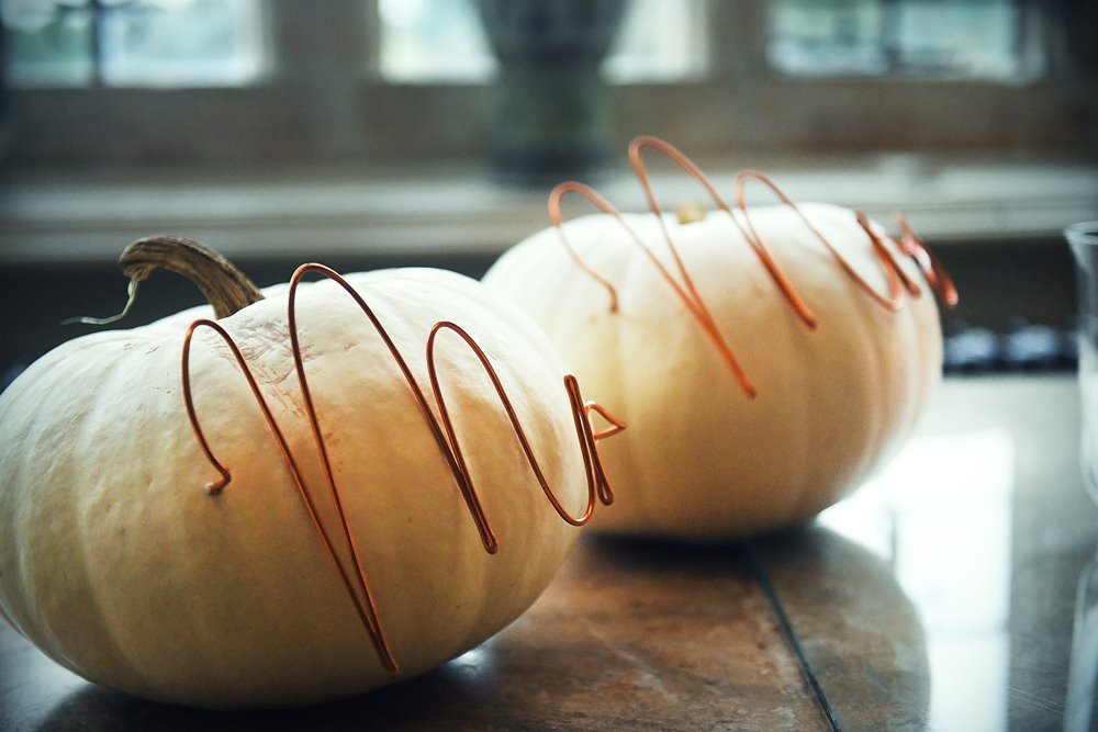 Wedding pumpkins decorated with Mr and Mrs signs in copper wire for a halloween wedding at manor house wedding venue elmore court 