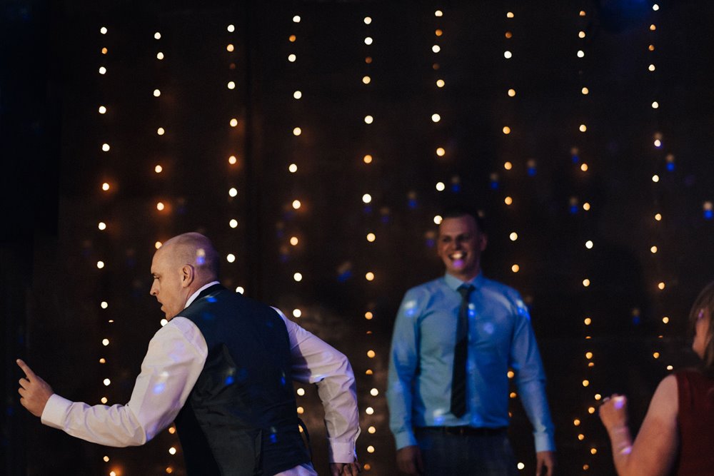 wedding guests dance in front of starry night theme backdrop at october party wedding in the cotswolds