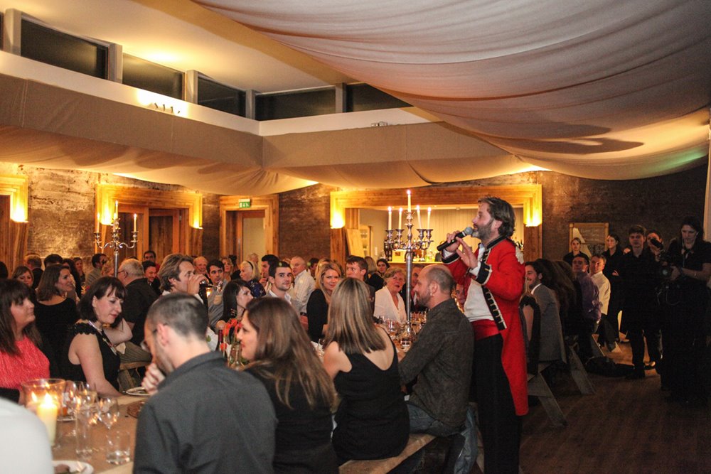 Hamish Guerrini entertains the crowd at funny dinner speech in the gillyflower festival wedding venue in gloucestershire