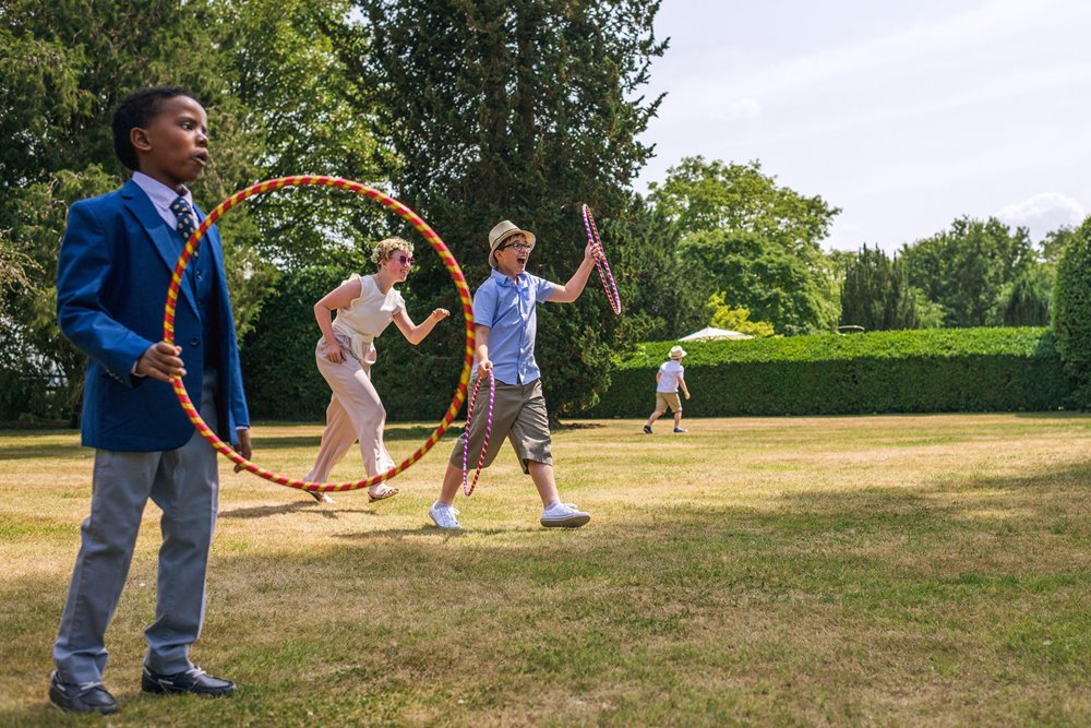 Children playing garden games at a same sex summer wedding outdoors in the Cotswolds