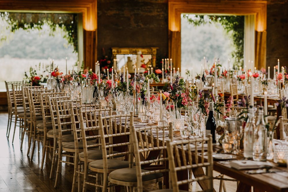 Pink florals and candles for a bright and boho wedding reception in the cotswolds
