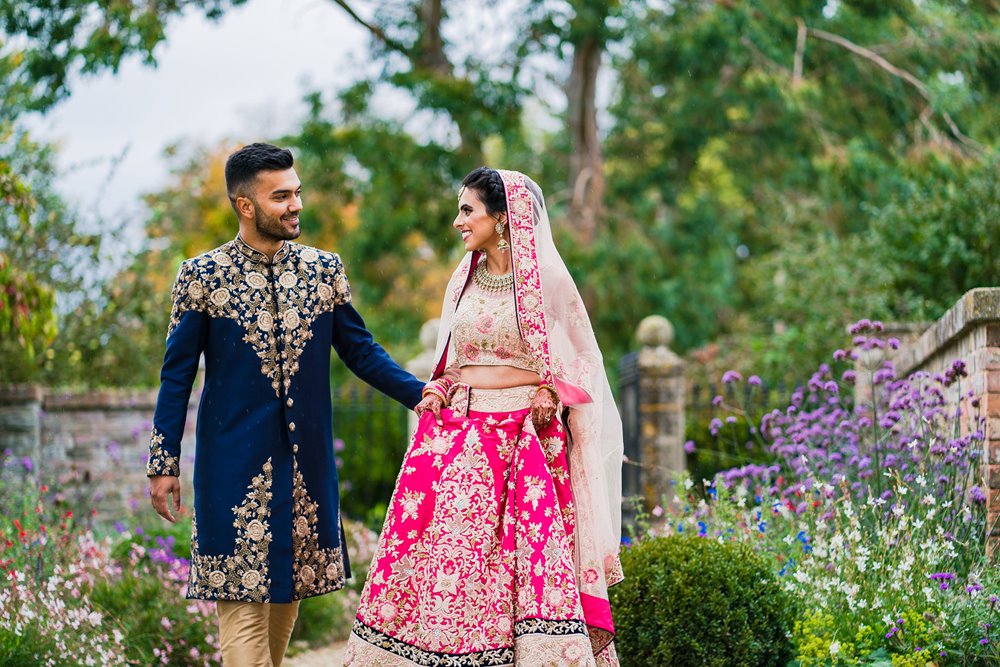 Indian bride and groom dressed in beautiful traditional clothes outdoors at elmore court