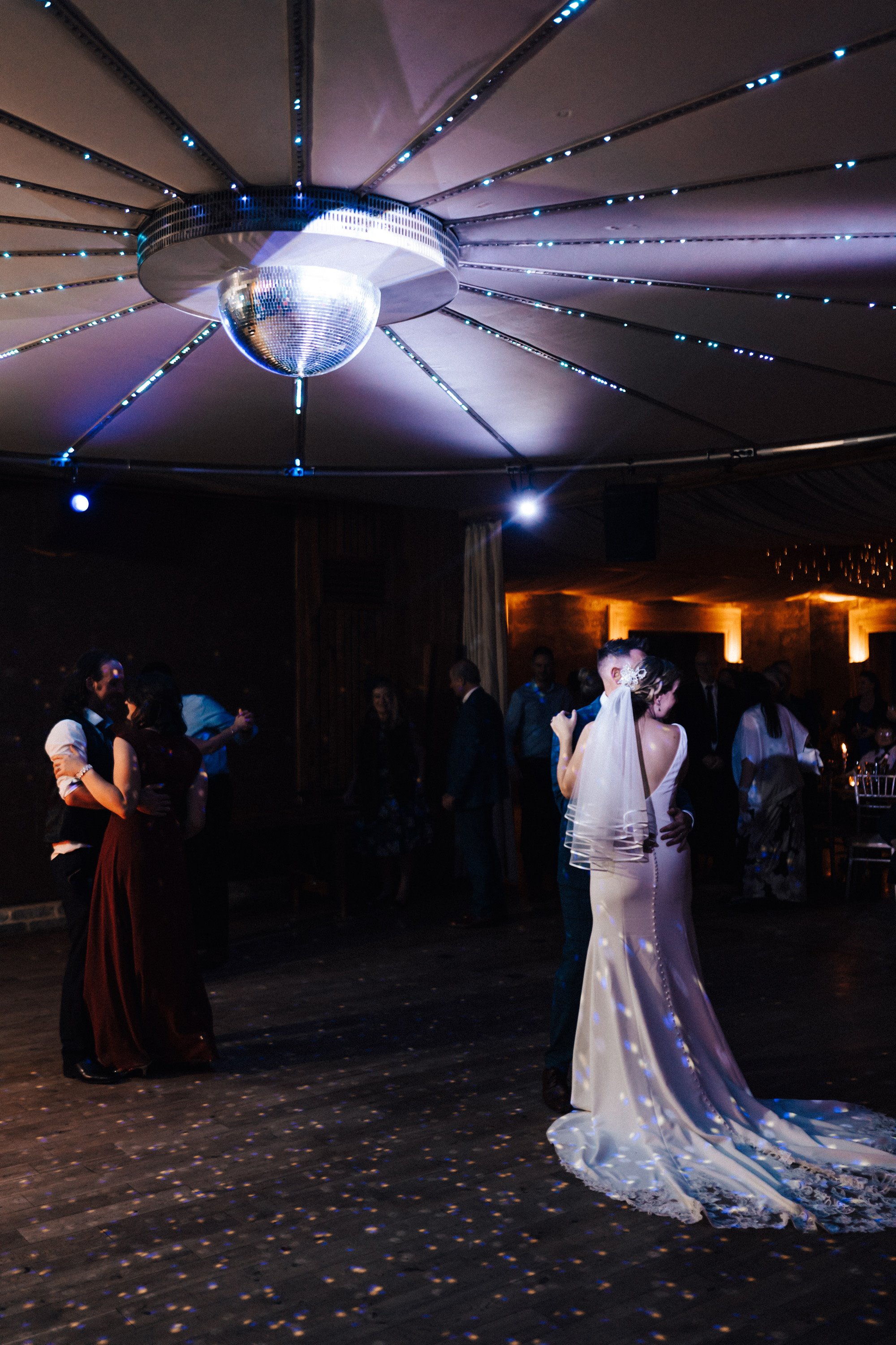 magical first dance under disco ball at christmas wedding party