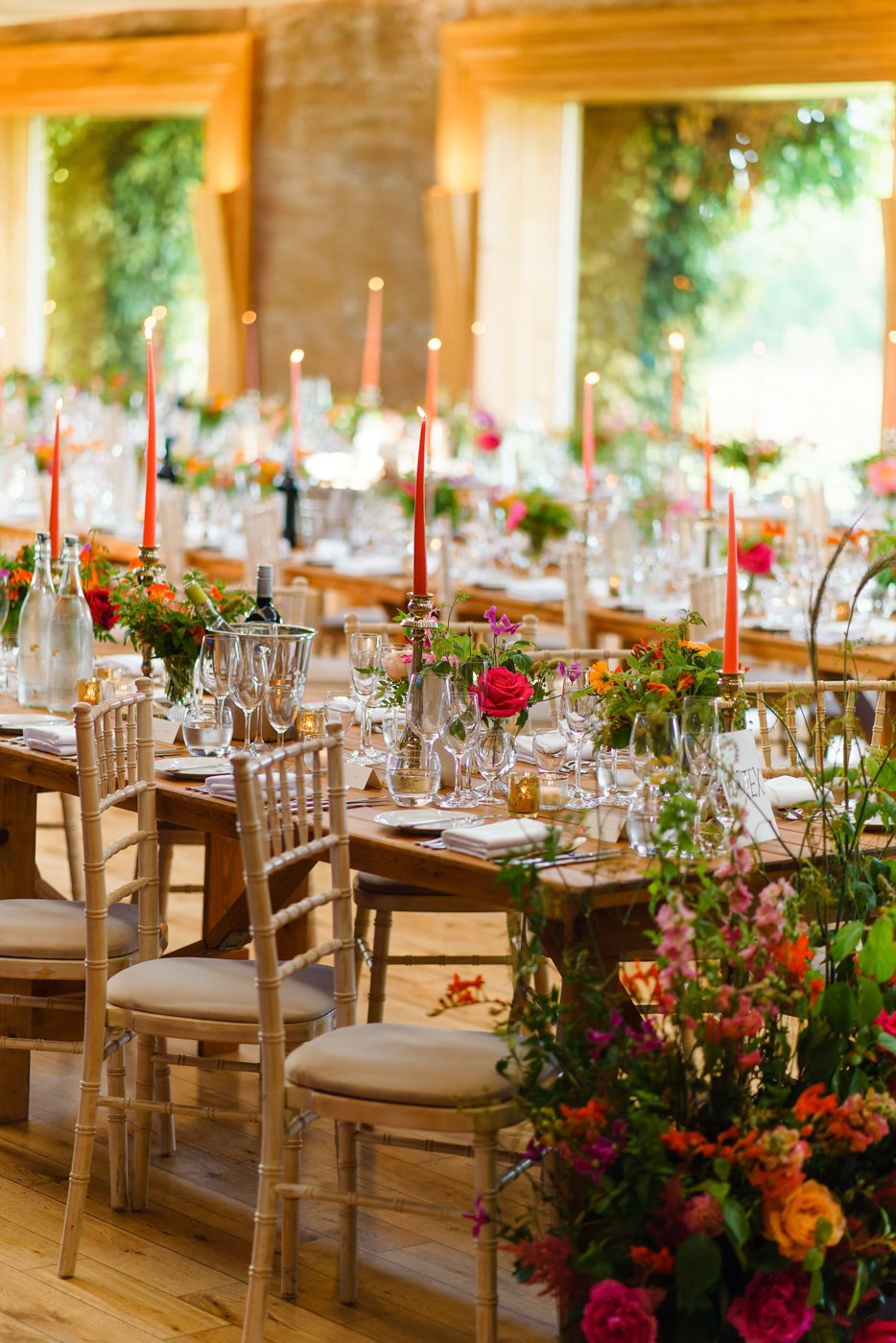Brightly coloured summer wedding inspo with pink and orange flowers and candles