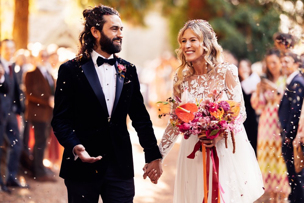 cool boho bride and groom covered in confetti