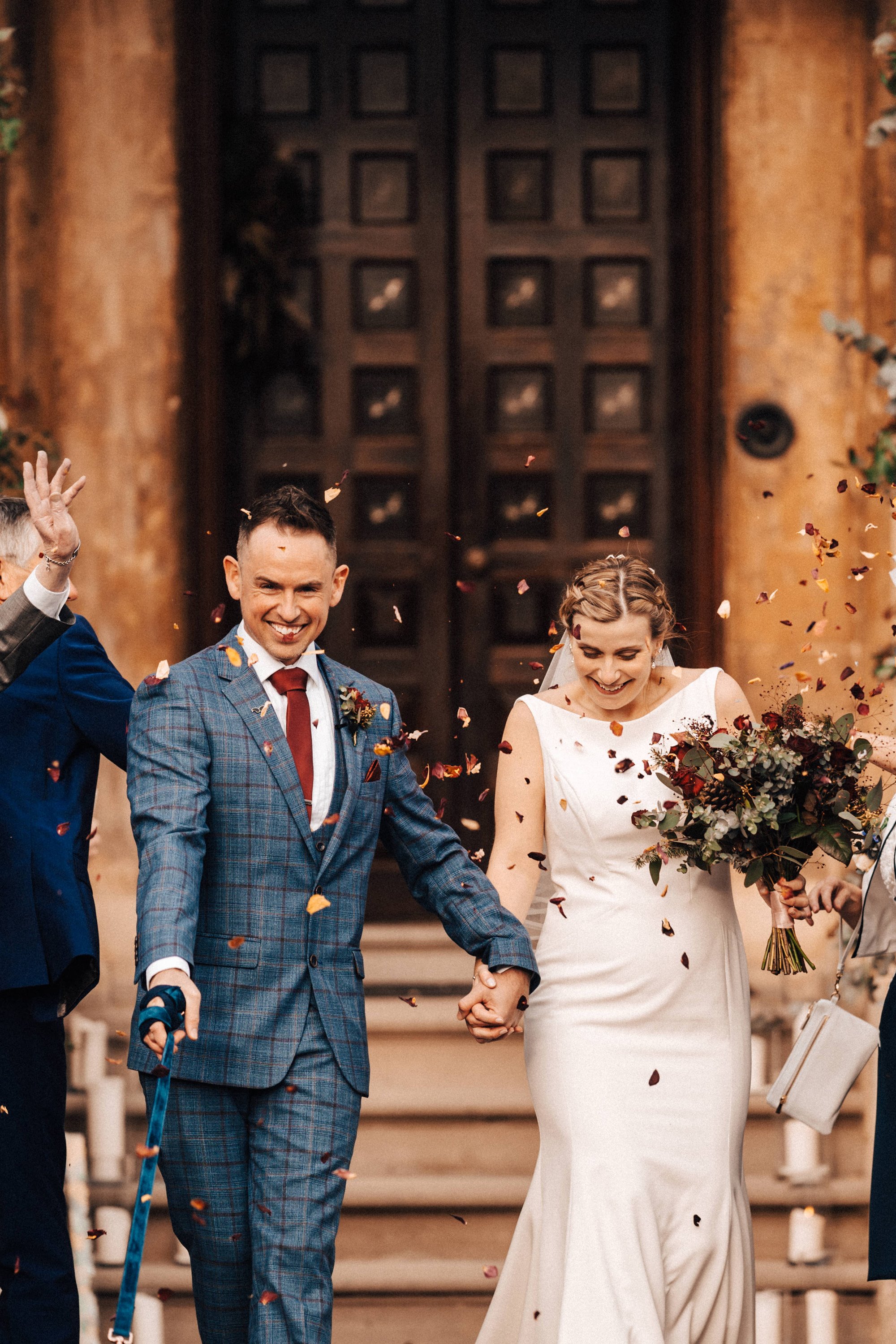 bride and groom confetti shot with christmas wedding bouquet