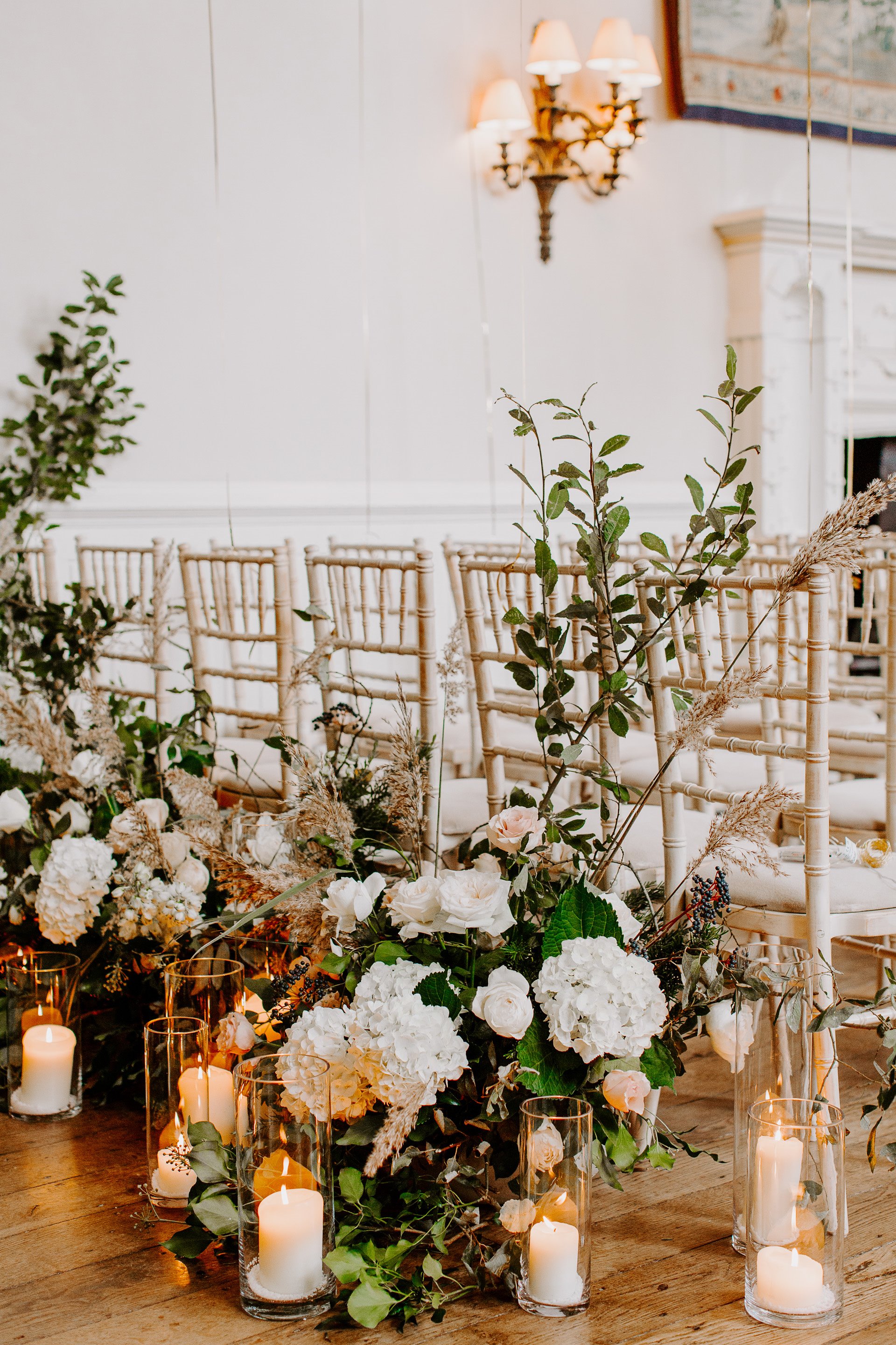 Romantic flowers decorating the backs of guests chairs at wedding ceremony in manor house elmore court