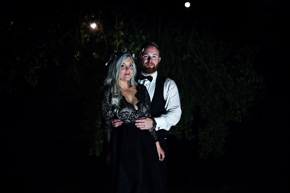 Gothic bride and groom on halloween wedding photoshoot with black wedding dress