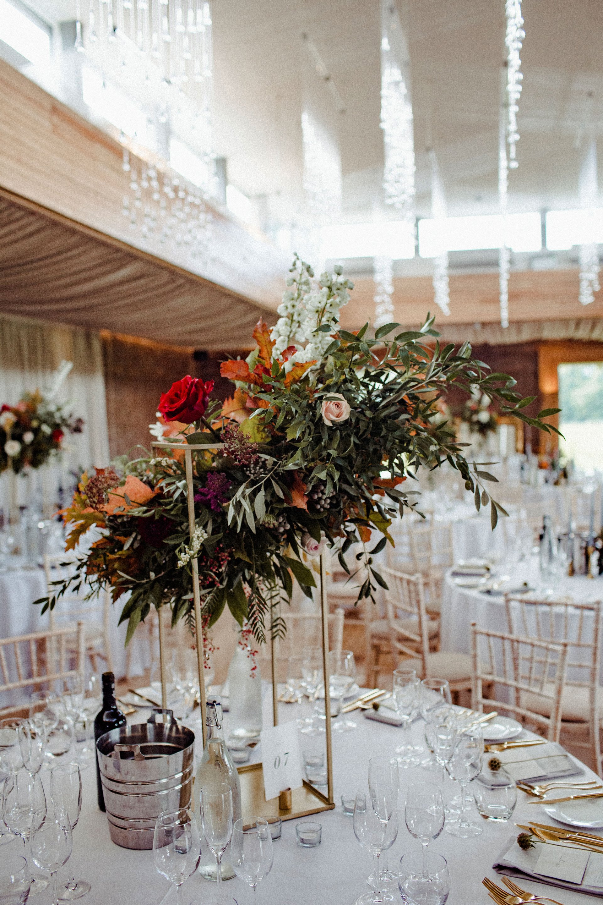 Asymmetric wedding flowers for autumnal reception in cotswolds country house 