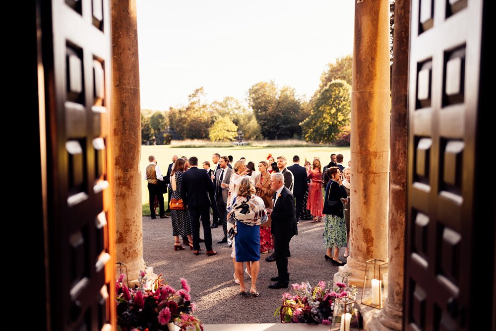 Colourful wedding flowers in sunny drinks reception outside elmore court