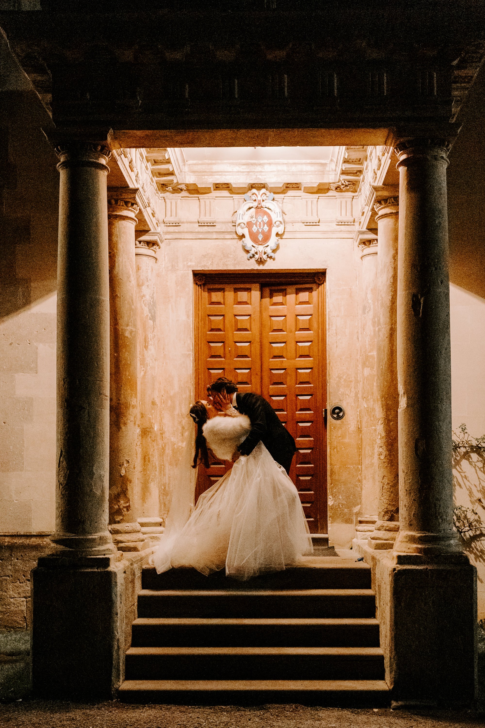 groom kissing his new wife on the steps of Elmore Court in Gloucestershire 