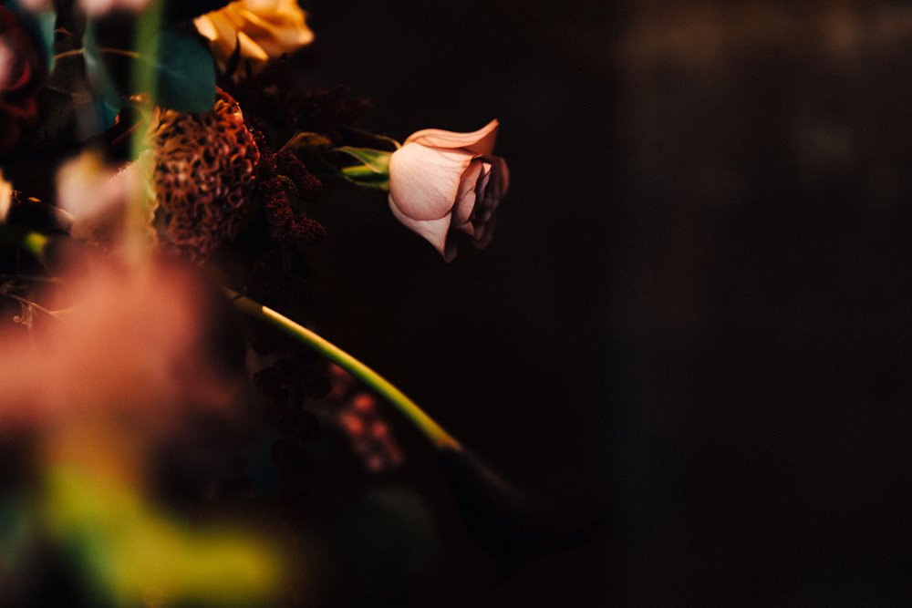 Dark and moody photo of autumnal wedding flowers at an october wedding with subtle halloween vibes 