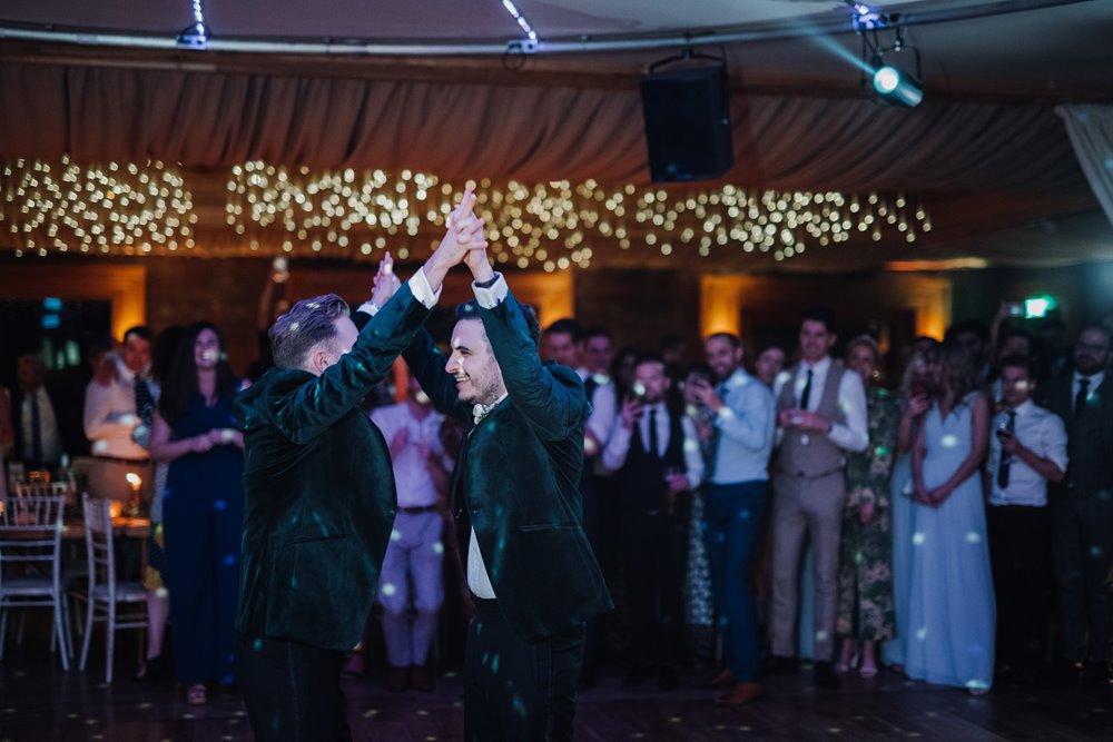 Gay wedding first dance for these two lovely grooms with twinkling lights in the background