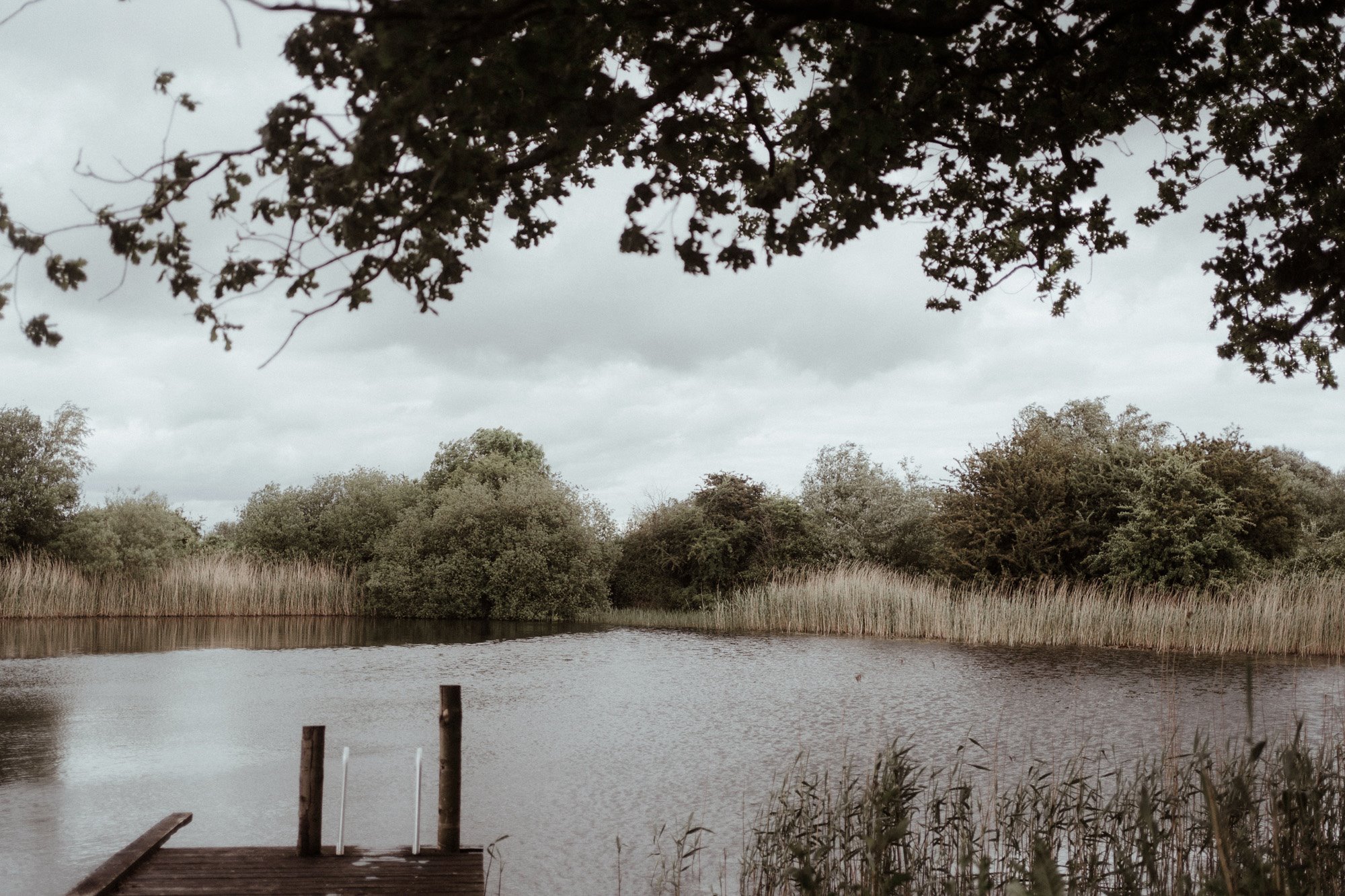 rewilding eco venue with wild swimming in spring fed lake in gloucestershire countryside