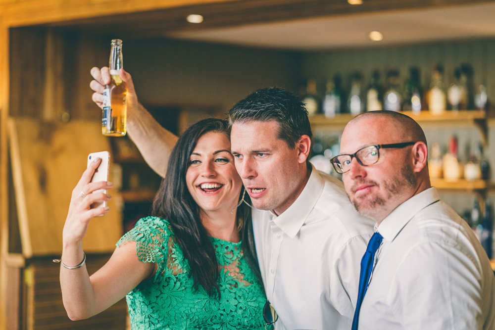 A funny wedding guest selfie is captured by the wedding photographer at Elmore Court