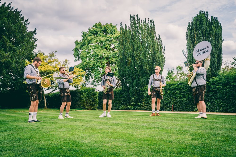 Fun wedding band german jukebox entertain guests on the lawn at wild wedding venue elmore court in gloucestershire