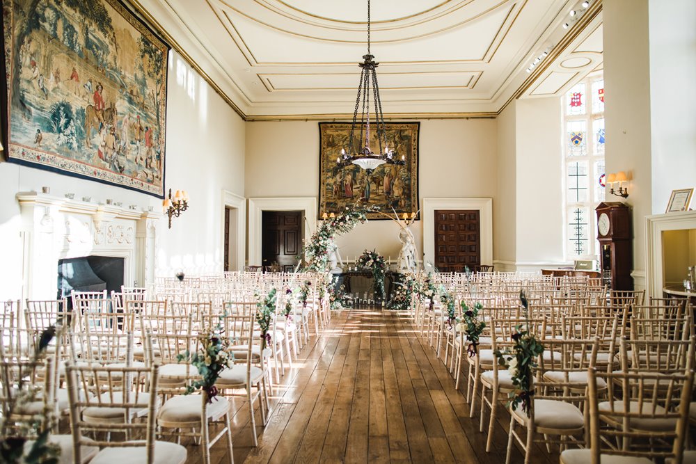 The hall at Elmore Court decorated with floral arch and flowers and peacock feathers for a massive weekend wedding