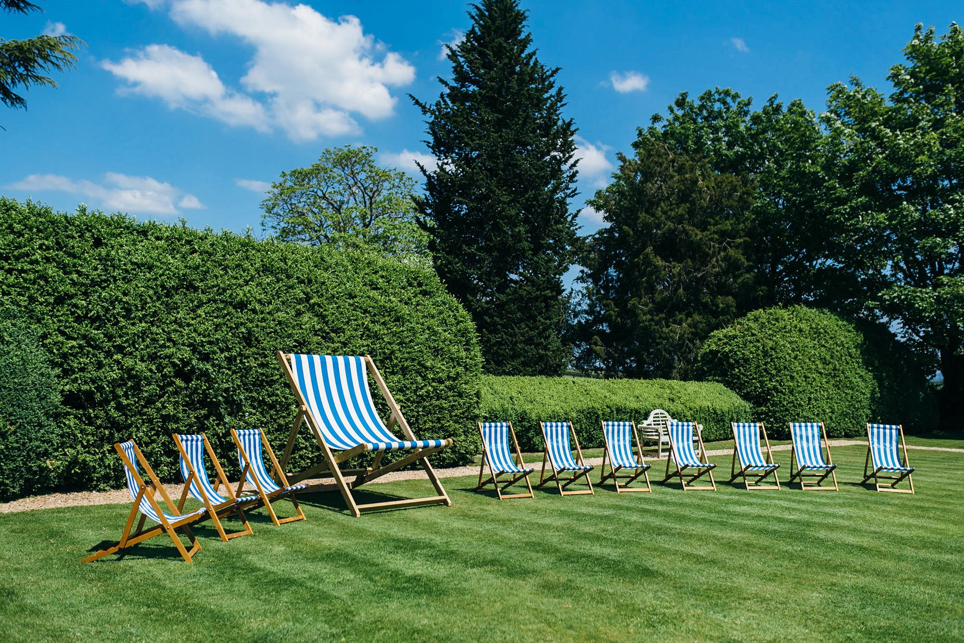 Fun outdoor wedding striped decor deckchairs with a huge one in the middle