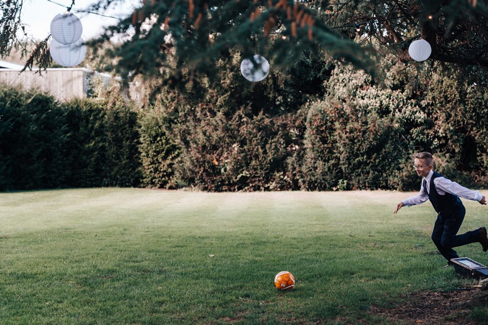 magical wedding with children playing in the gardens of stately home venue in the cotswolds countryside