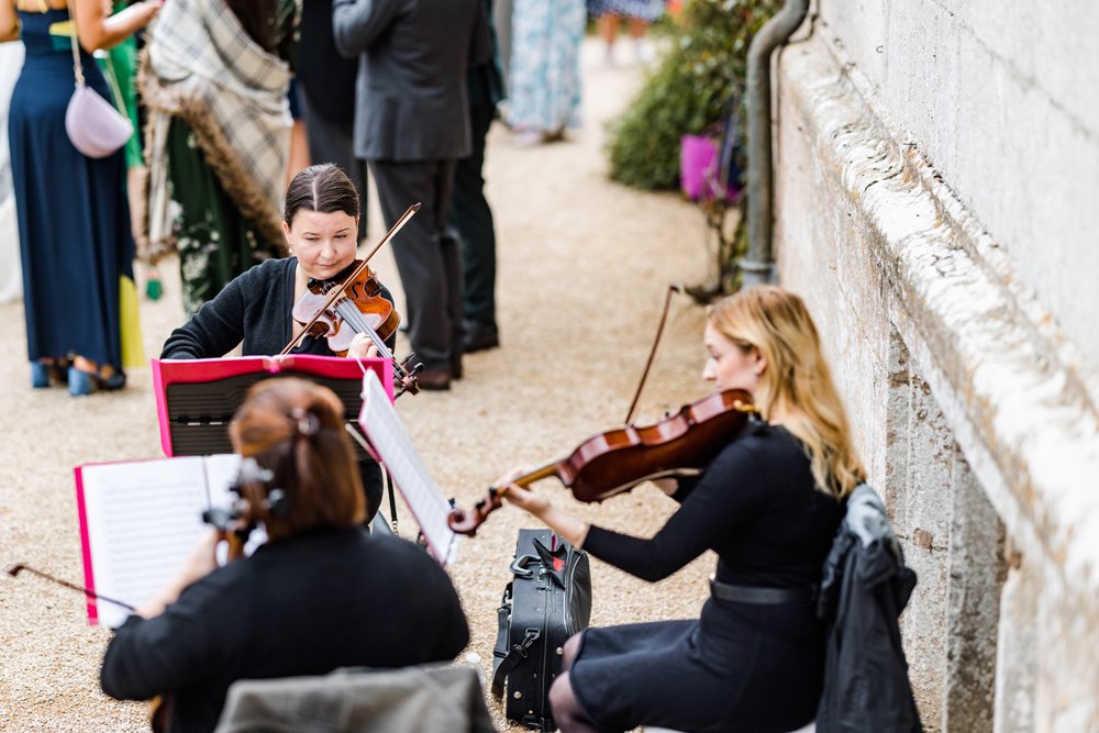 A string quartet playing at an outdoor wedding reception in the Cotswolds