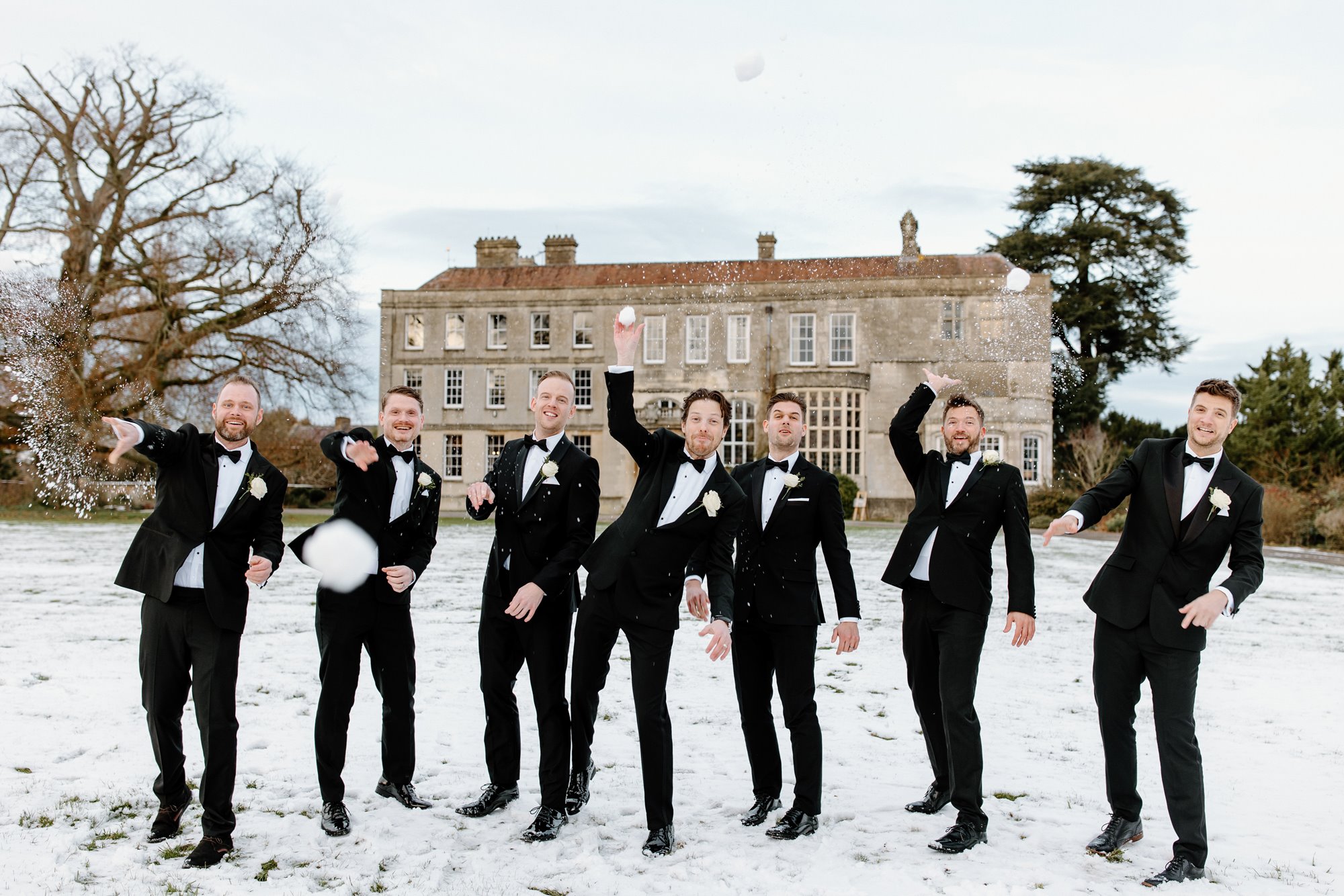 Groom and his groomsman throwing snowballs at Elmore Court