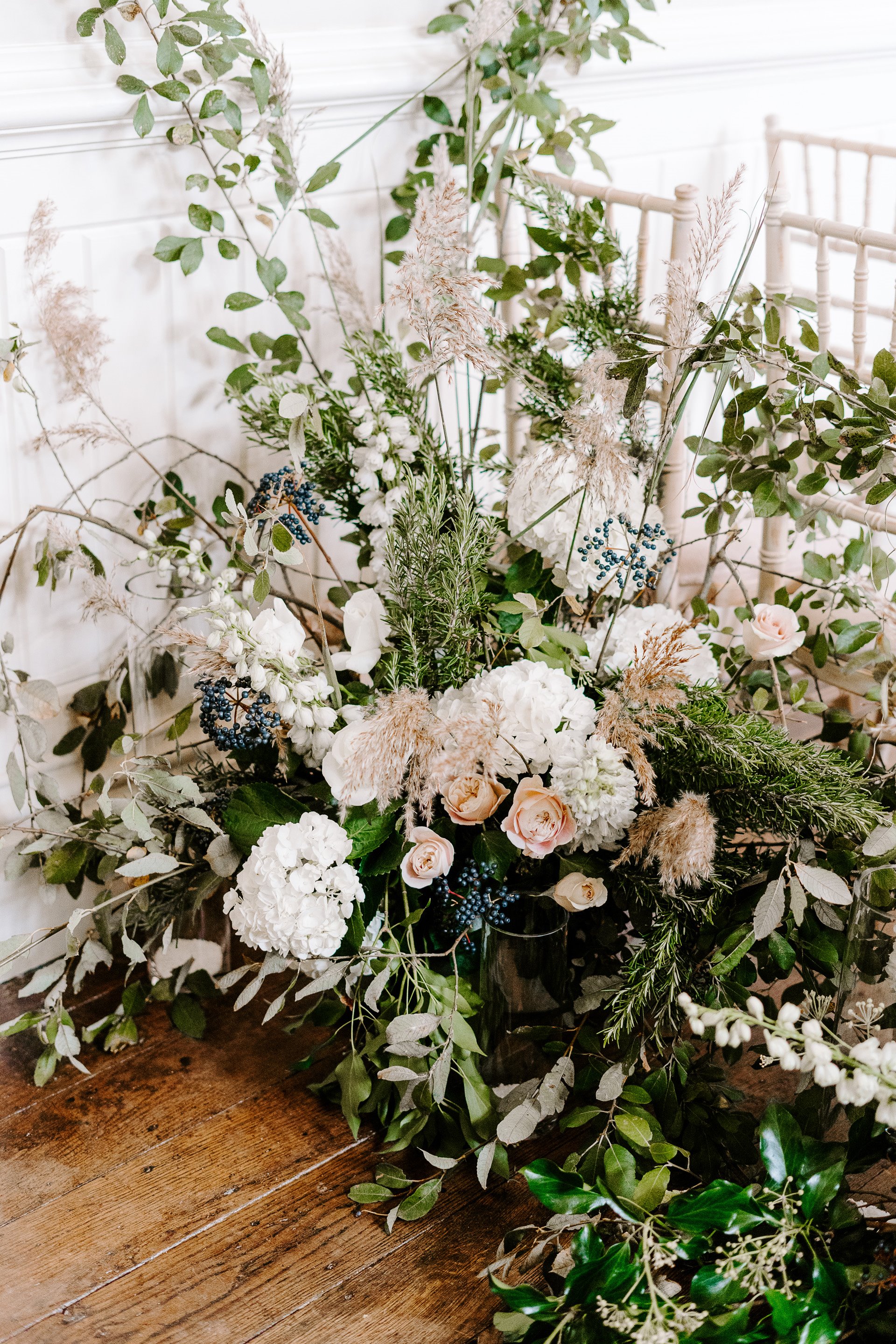 Fluffy white wedding blooms decorate the aisle of this romantic ceremony in the cotswolds