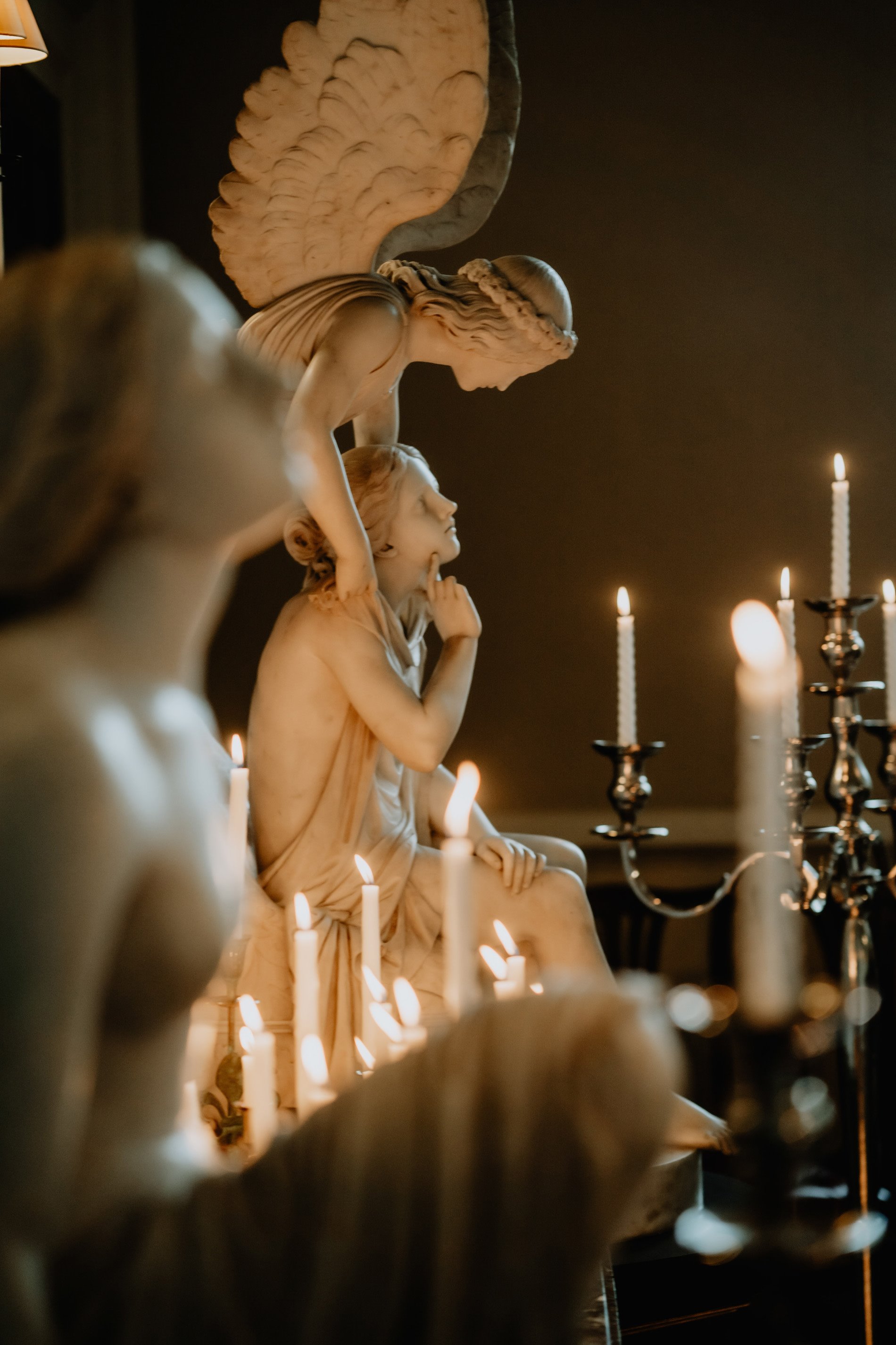 dark and moody wedding inspiration at candlelit wedding ceremony with huge angel statues