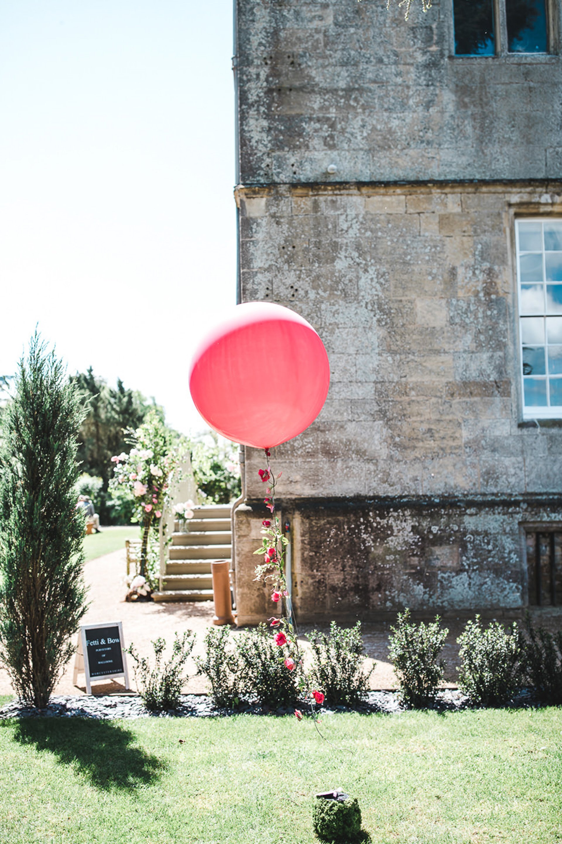 Pink balloon with roses on the string to decorate an outdoor wedding in the UK