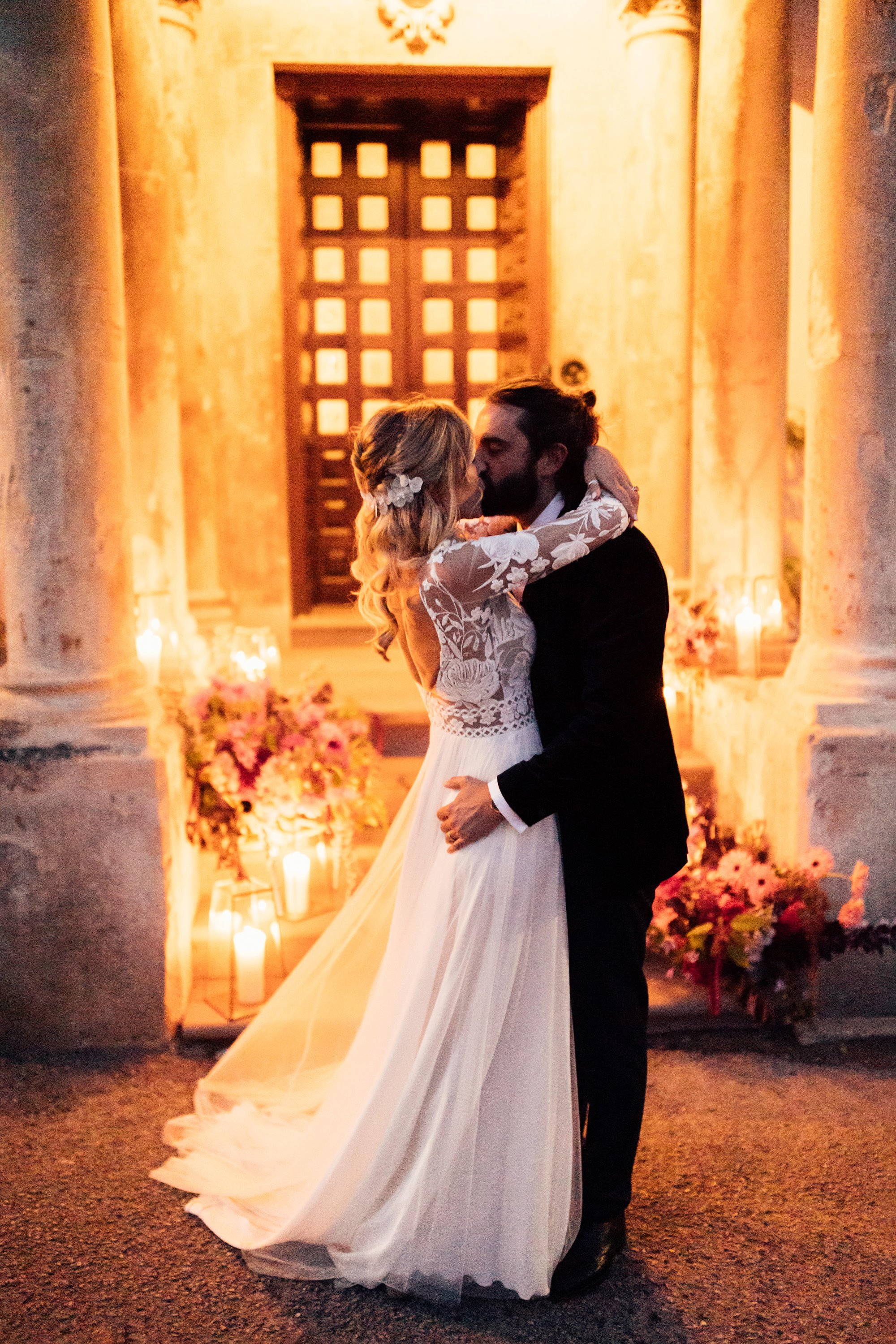 candle lit pose with a bride and groom kissing outside a stately home and wedding venue in gloucestershire