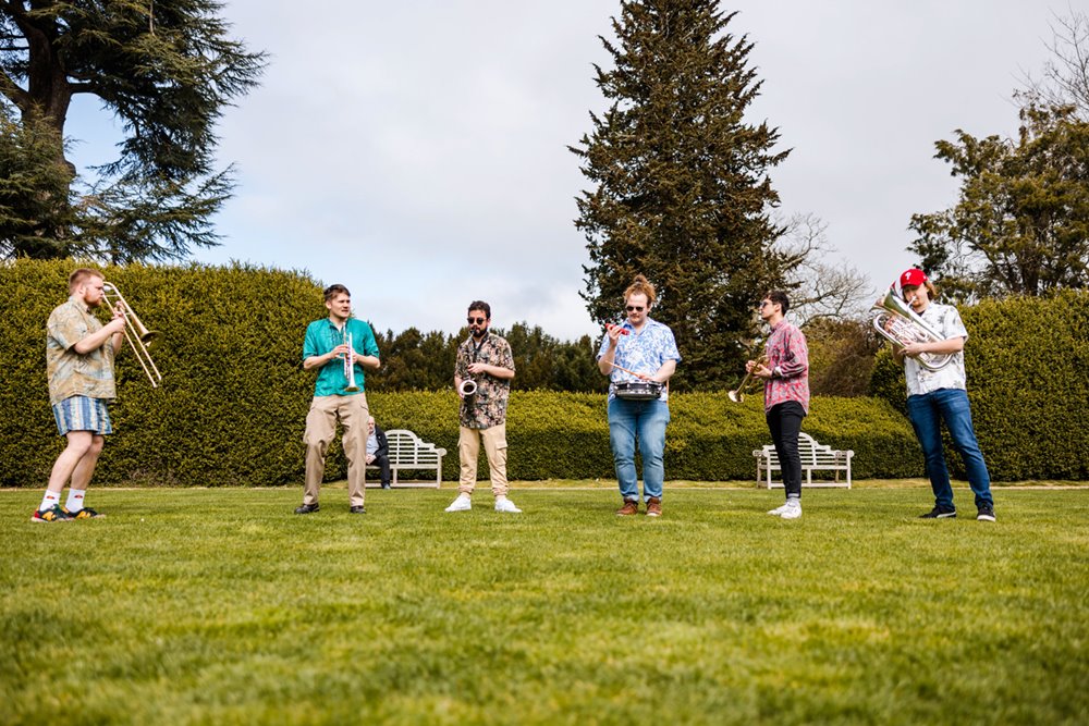 Danger goat brass band play on the lawn outside elmore court for festival wedding fair in gloucestershire