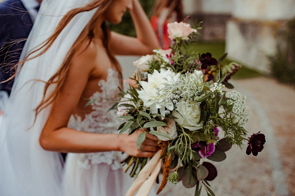 Romantic boho bouquet held by cool bride in pre-raphaelite dress at her autumnal wedding