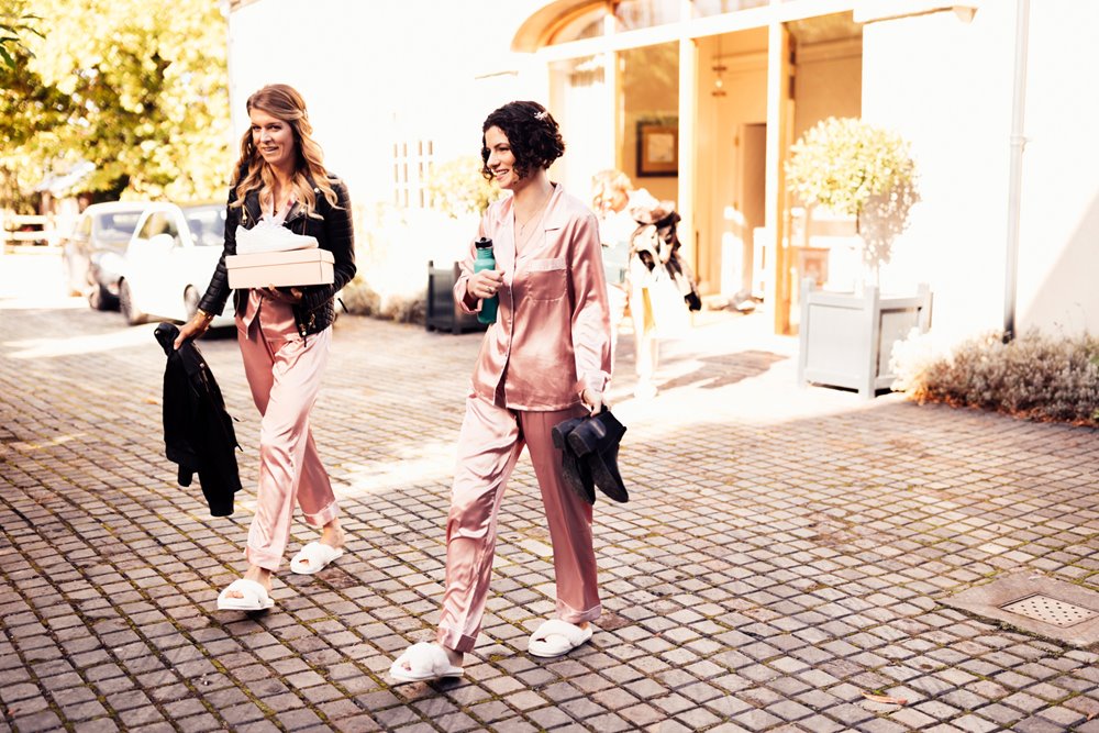 bridesmaids in pyjamas walking across to stately home for getting ready