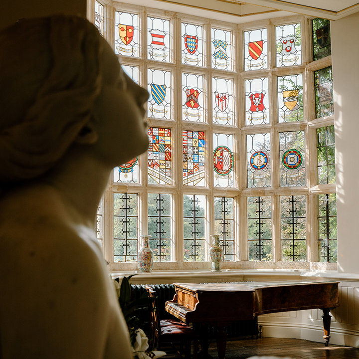 Luxurious wedding photography of a stately home wedding venue with stained glass windows and marble statues