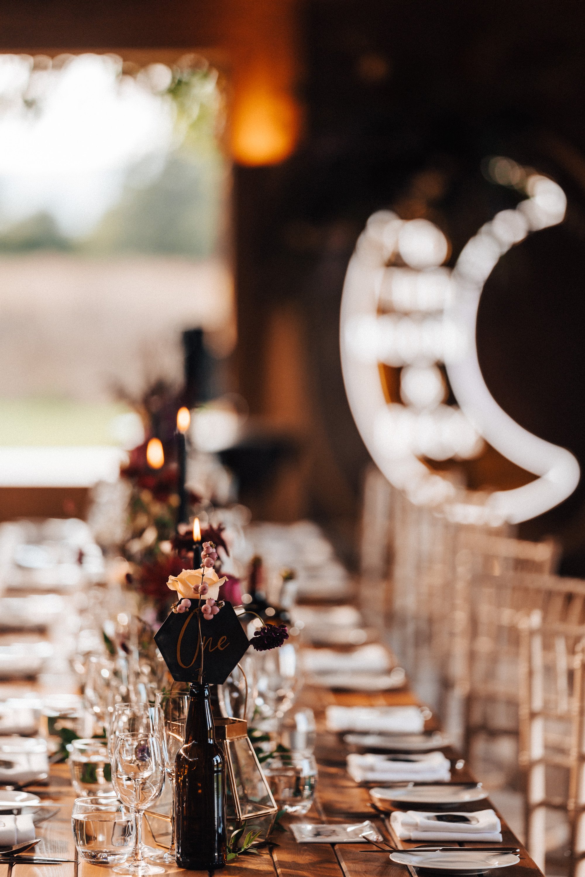 Celestial wedding reception with black cake and candles, autumnal flowers and touches of halloween for a magical celebration in Gloucestershire