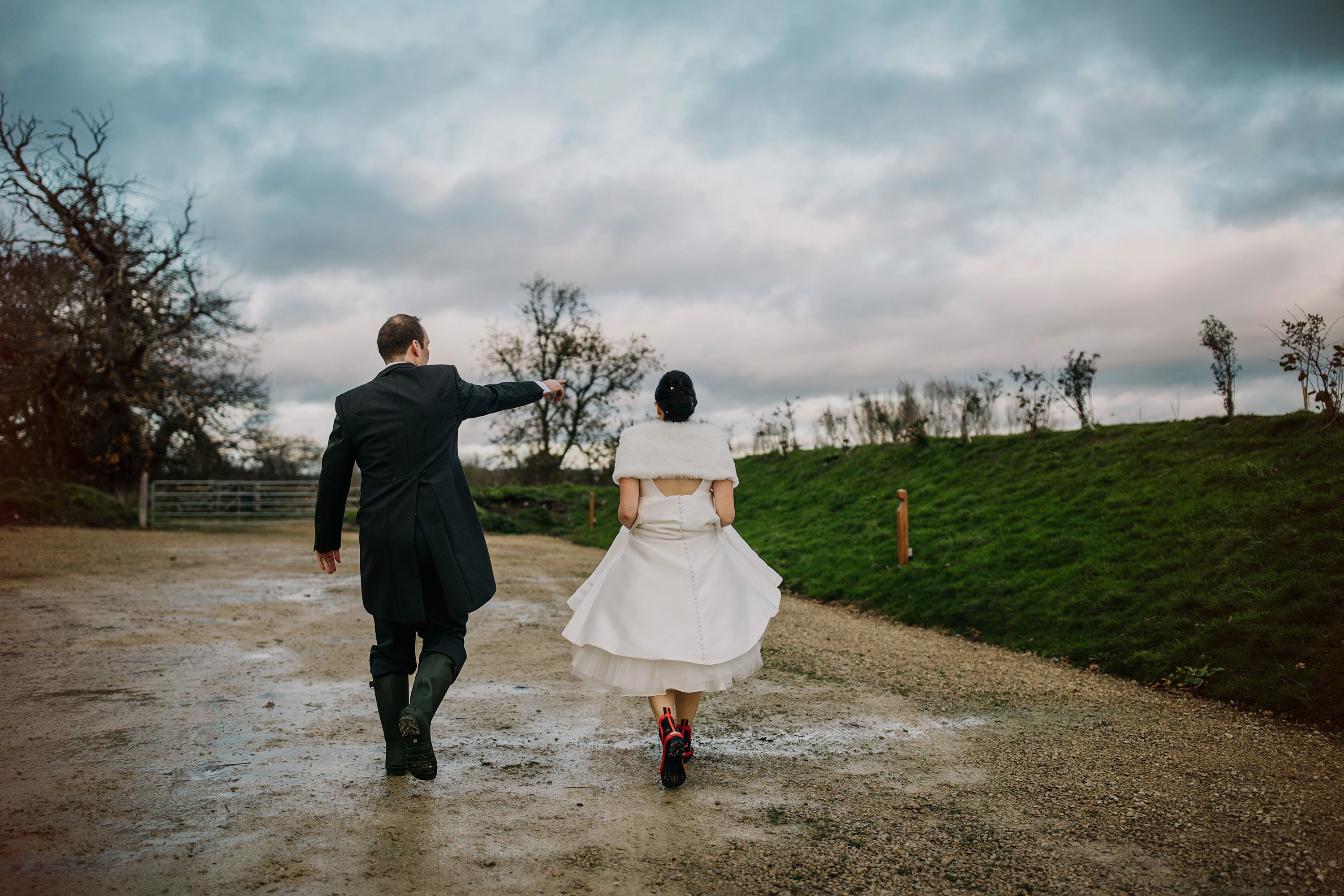 Bride wearing wellies and shawl on a rainy day