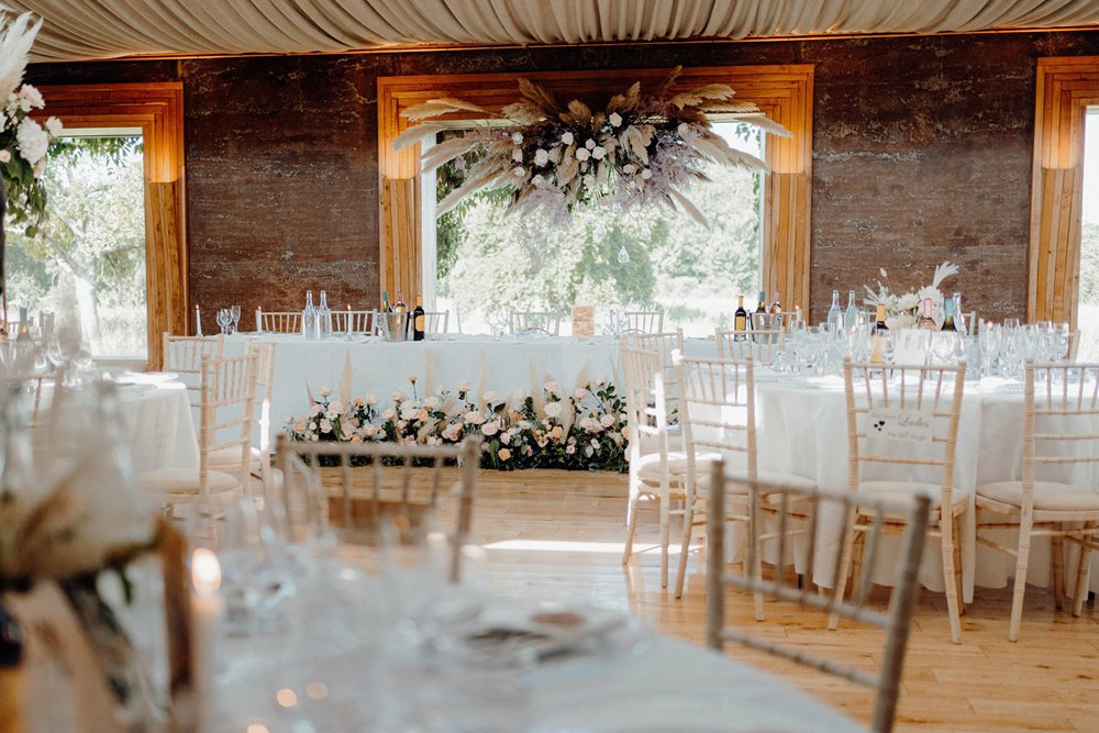 statement pampas grass and roses decorating the top table at romantic wedding reception