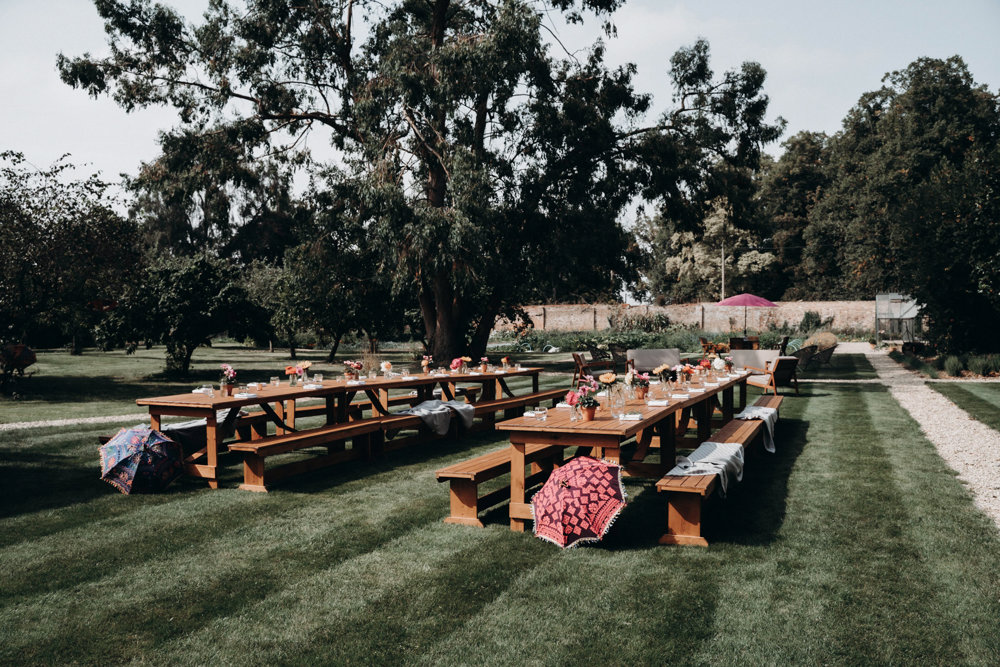 walled garden wedding with benches and indian parasols decor for an outdoor wedding at elmore court