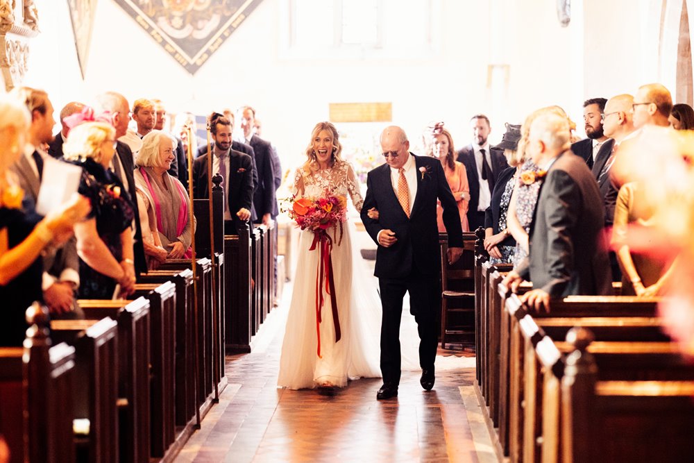 bride and father walk down the church aisle in wedding ceremony at elmore in gloucester