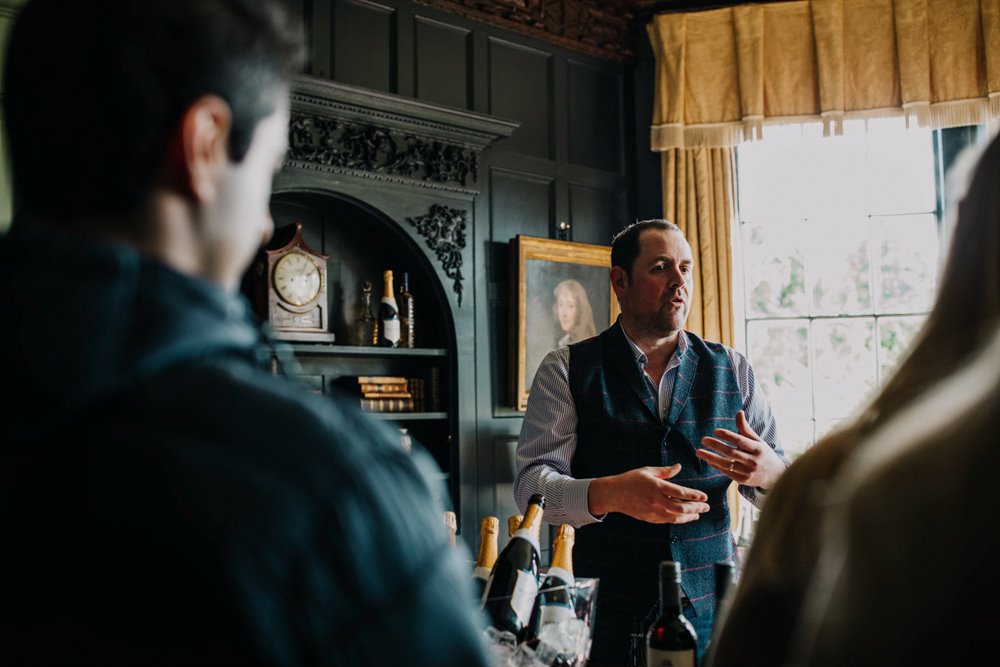 sommelier giving wine advice and tasters at wedding fair in the cotswolds