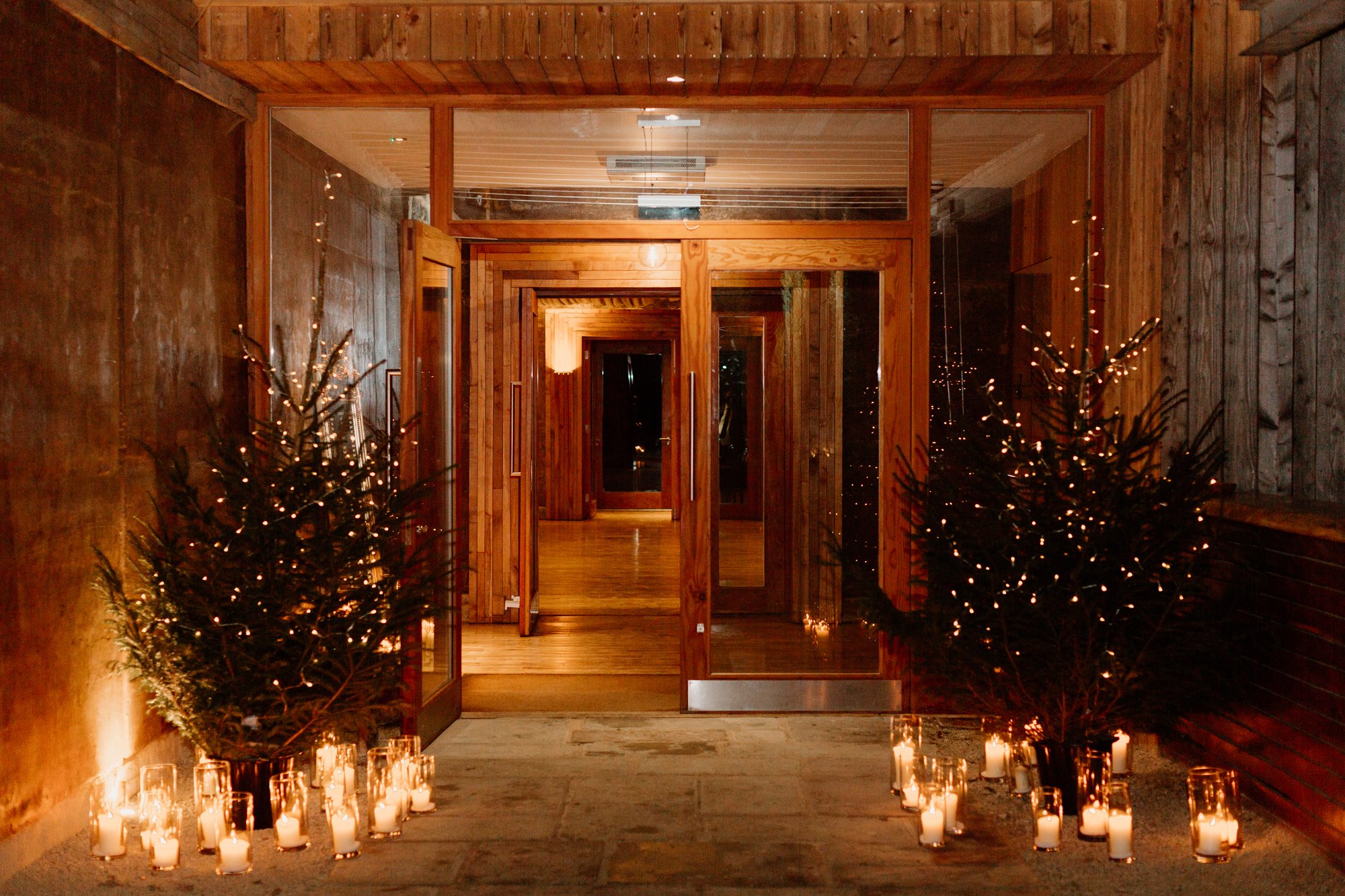 fairy lights on trees with candles scattered below them, at the entrance to the gillyflower at Elmore Court