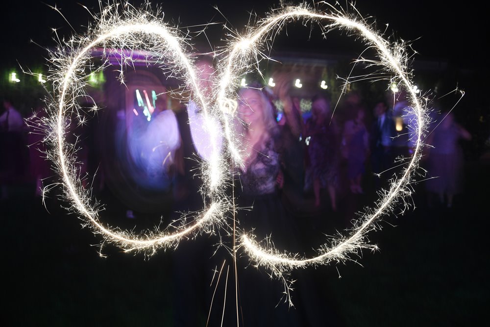 Bride in black wedding dress and groom with sparklers at their autumn themed wedding