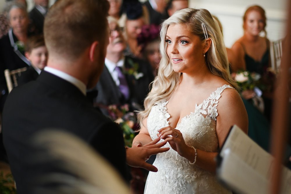 autumnal wedding ceremony bride and groom exchanging rings