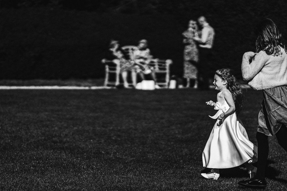 children playing at wedding post covid in black and white moody photos