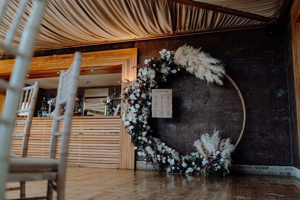 romantic modern wedding arch with pampas grass and roses in a circle 
