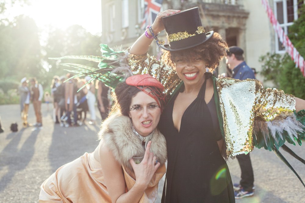 festival wedding guests in front of mansion house elmore court looking very happy to be there