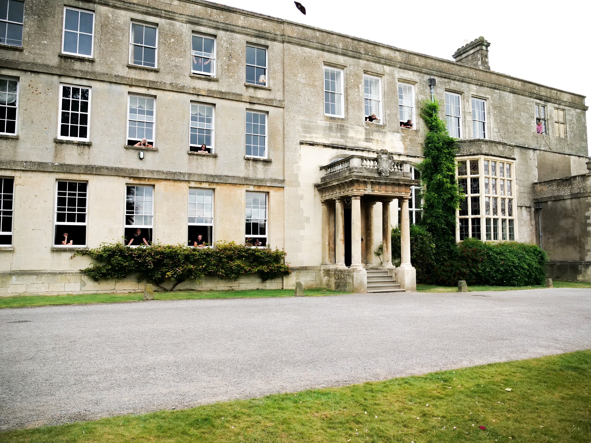 all of the housekeeping team looking out the windows of mansion house elmore court in the cotswolds