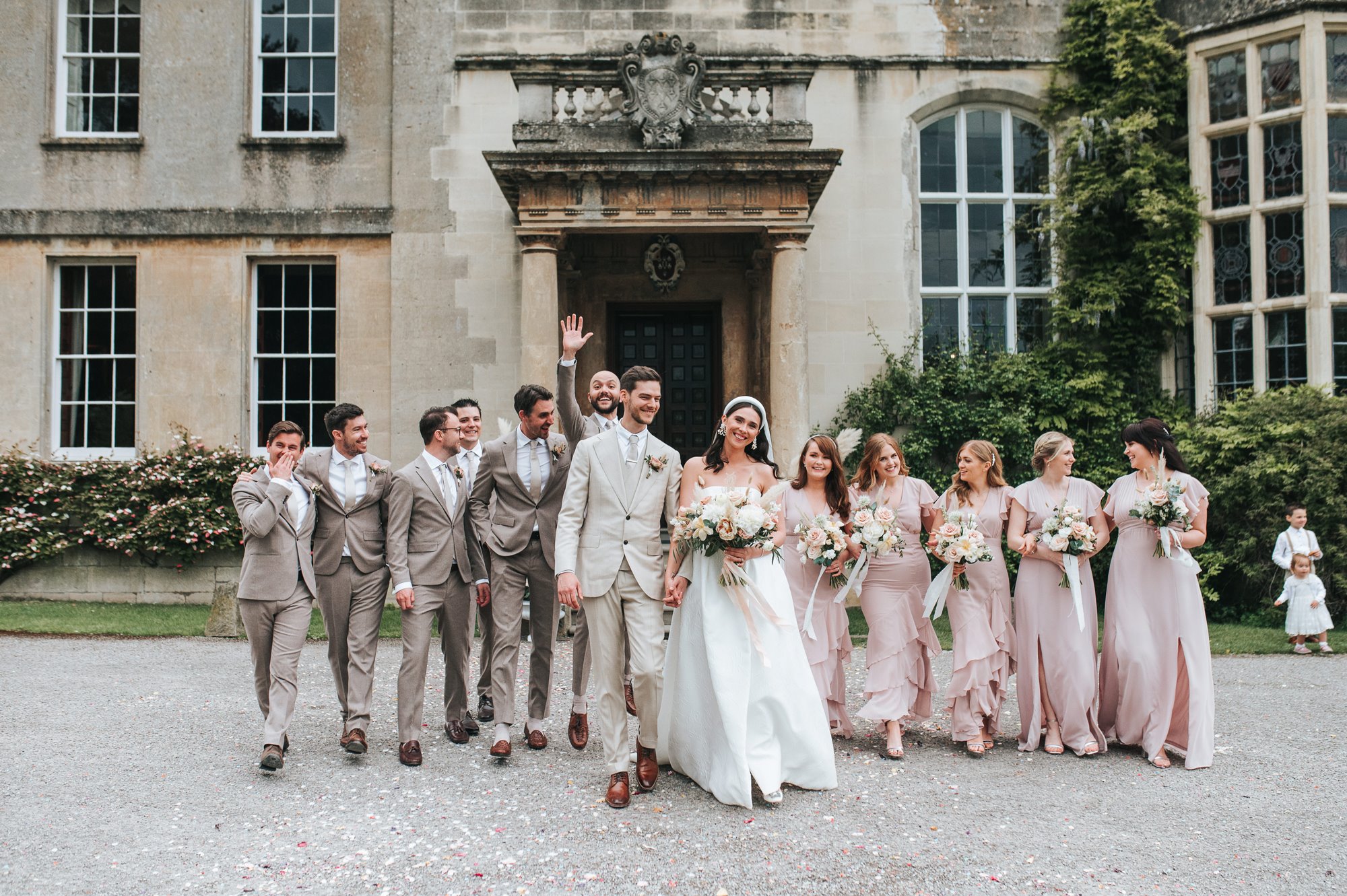 bridal party and grooms party wearing pastel colours at a Gloucestershire stately home and wedding venue