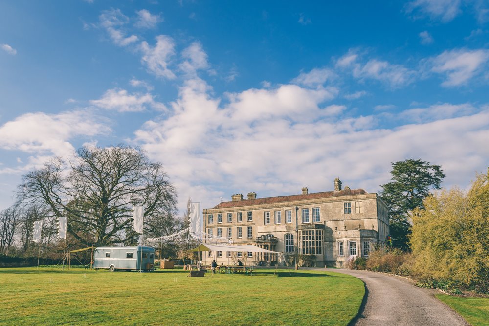 Bunting and outdoor wedding food vendors set up on the front lawn at cotswolds wedding venue elmore court for a vintage garden party wedding